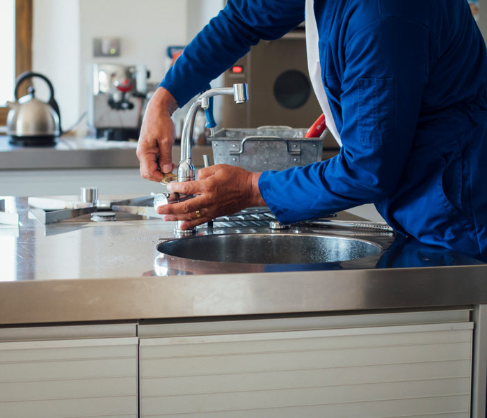 plumber working on kitchen faucet